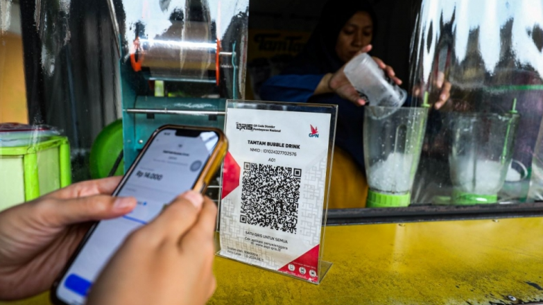 transaksi qris - Ilustrasi warga melakukan pembayaran digital menggunakan transaksi QRIS yang kini semakin mendominasi perekonomian nasional.